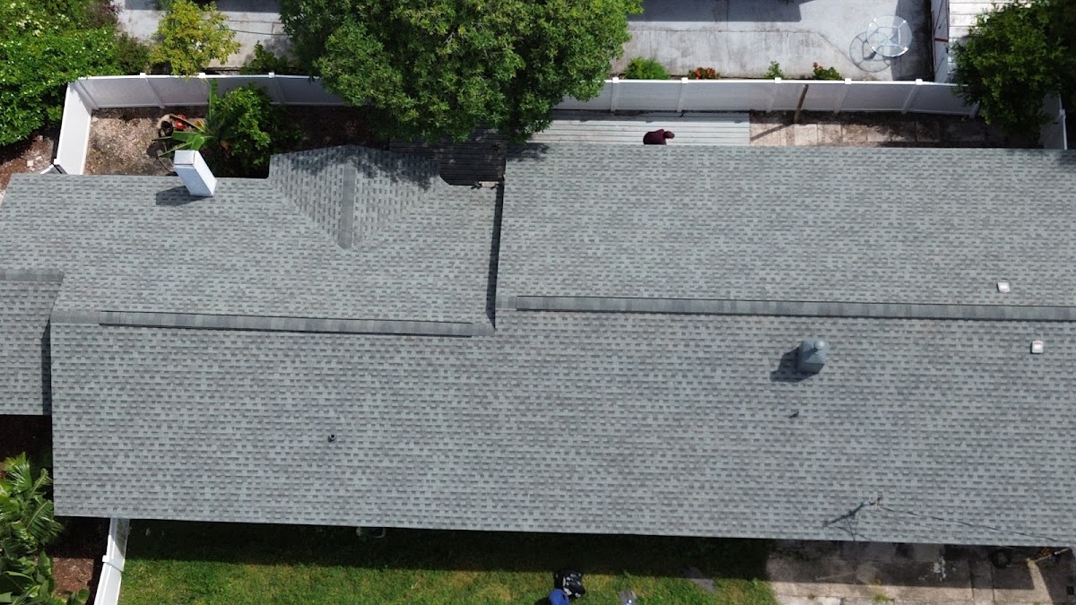 Roofing work across a broad shingle roof